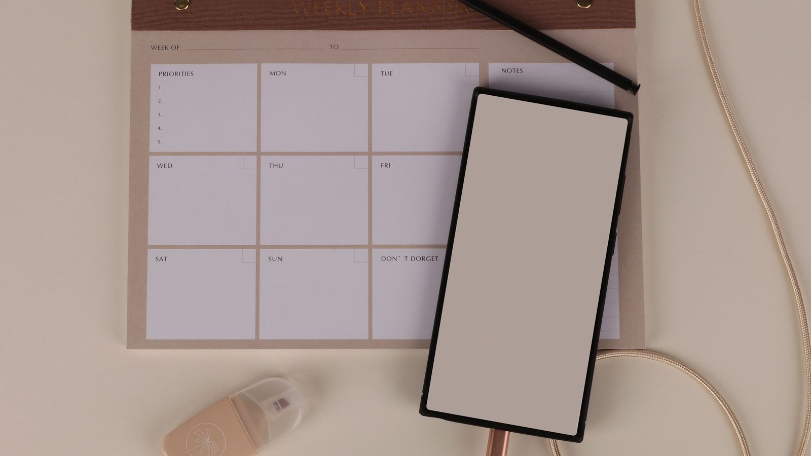 Smartphone accanto a un planner settimanale su una scrivania